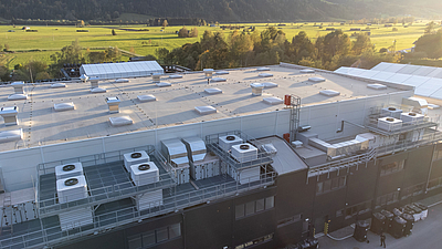 Beim Kunststoffverarbeiter Senoplast in Piesendorf sorgen fünf Sustainable Hall Conditioning Anlagen mit bis zu 126.000 m³/h gekühlter Frischluftzufuhr für ein angenehmes Arbeitsklima und stark reduzierte Treibhausgas-Emissionen. © Infranorm