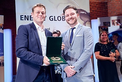 Landesrat Stefan Kaineder überreicht eine Ehrenmedaillen an KC-Projektassistent Johannes Poldlehner