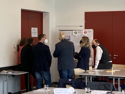 6 der Teilnehmer:innen des QM Plattformtreffens arbeiten gemeinsam an einer Tafel  ©Business Upper Austria